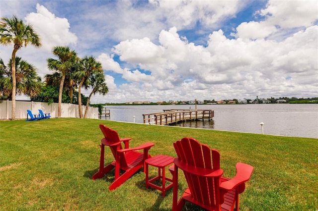 view of dock featuring a lawn and a water view