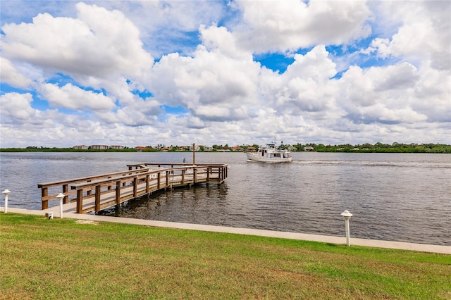 dock area with a yard and a water view