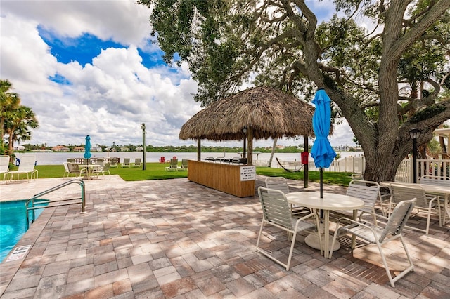 view of patio with a water view and a community pool