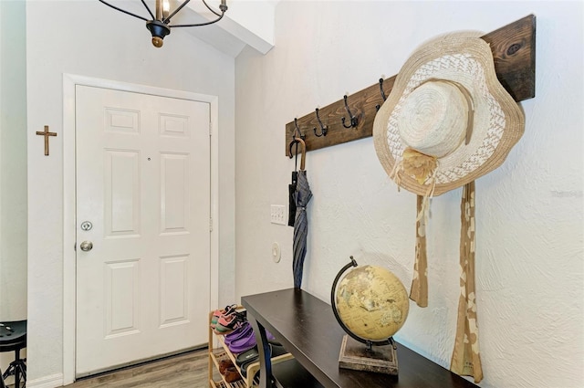 mudroom with hardwood / wood-style flooring, lofted ceiling, and a notable chandelier