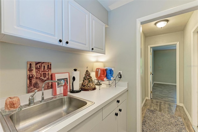 kitchen featuring light wood-type flooring, white cabinetry, and sink