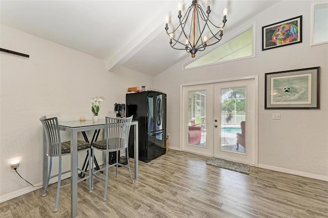 dining space featuring lofted ceiling with beams, french doors, hardwood / wood-style floors, and an inviting chandelier