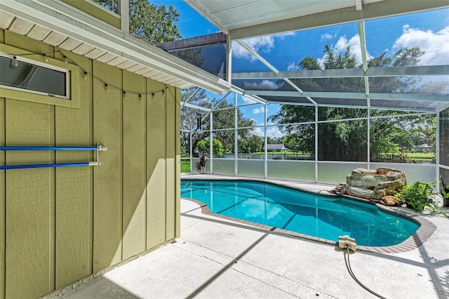 view of pool featuring glass enclosure and a patio area