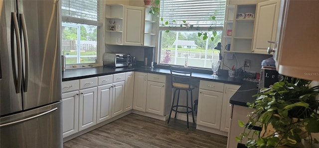 kitchen with stainless steel refrigerator, dark hardwood / wood-style flooring, and white cabinets