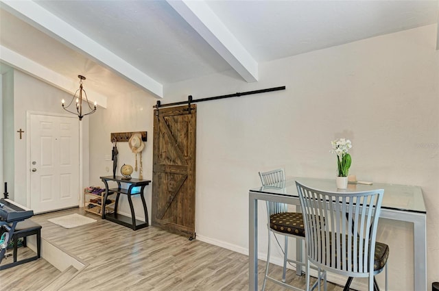 dining room with a barn door, light hardwood / wood-style flooring, lofted ceiling with beams, and a notable chandelier