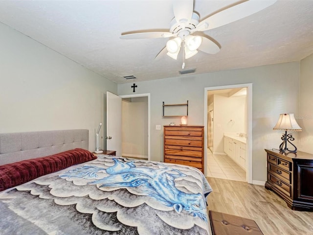 bedroom featuring ceiling fan, light hardwood / wood-style floors, and ensuite bathroom