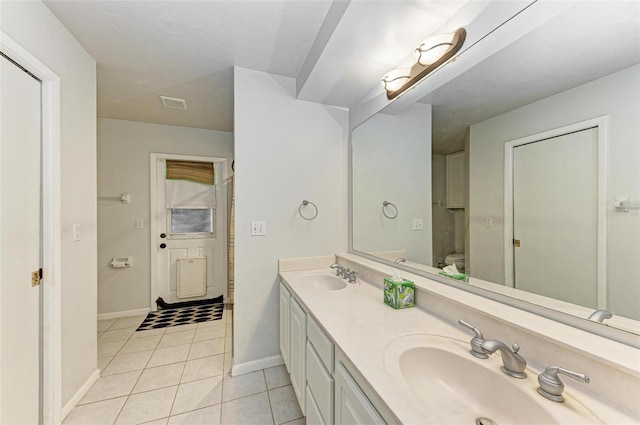 bathroom featuring tile patterned floors, vanity, and toilet