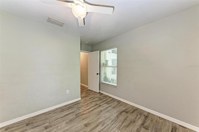 empty room with hardwood / wood-style floors, a textured ceiling, and ceiling fan