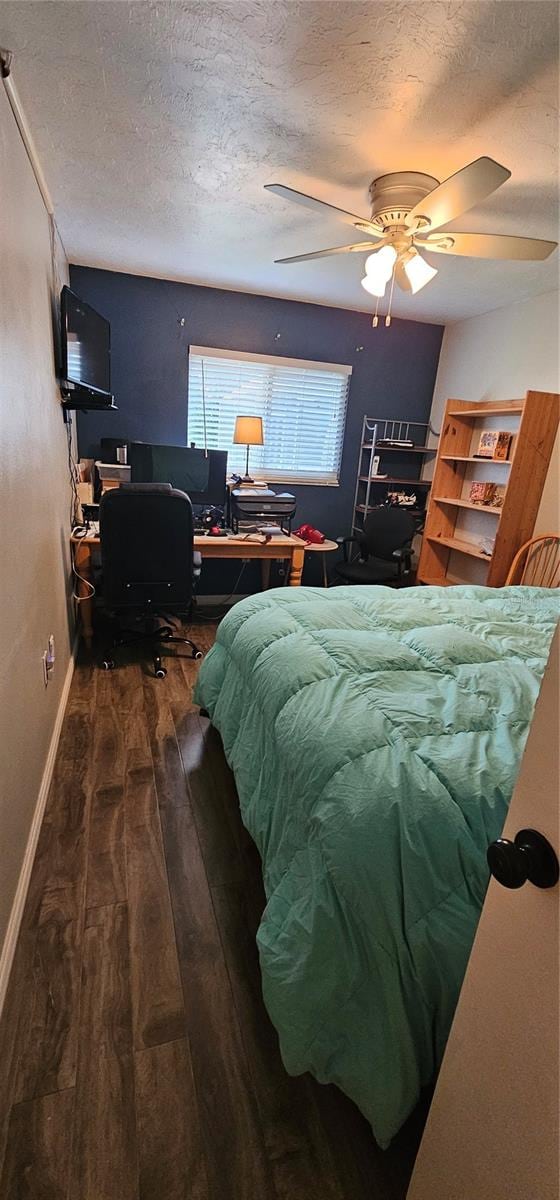 bedroom featuring a textured ceiling, dark hardwood / wood-style floors, and ceiling fan