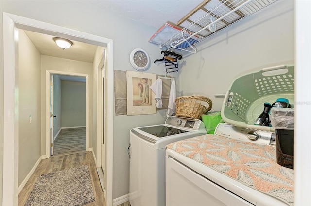 laundry area with washer and clothes dryer and light hardwood / wood-style flooring