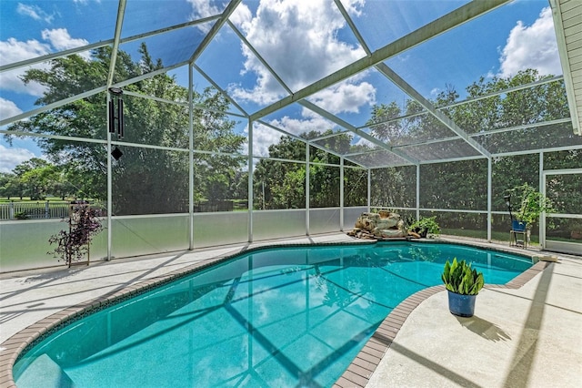 view of swimming pool with glass enclosure and a patio