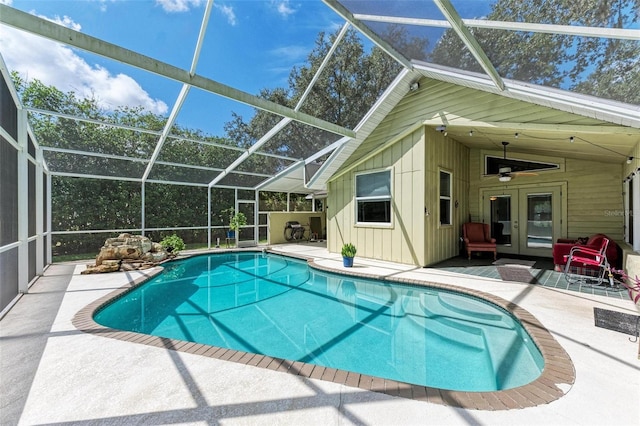 view of swimming pool featuring ceiling fan, a lanai, a patio, and french doors