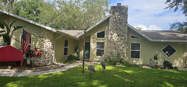 back of property featuring a lawn