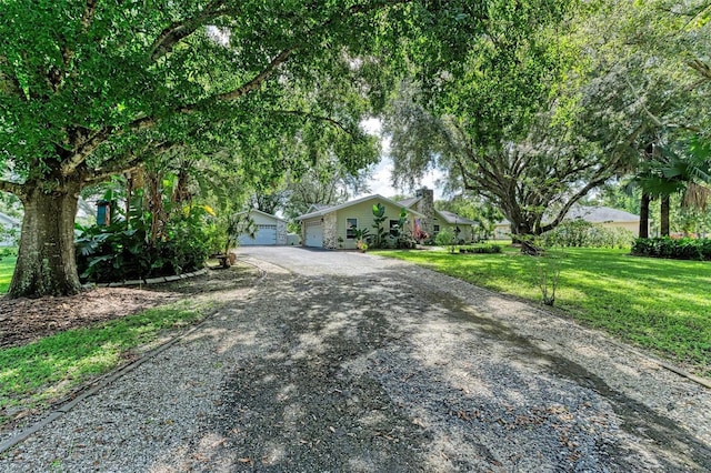 ranch-style home featuring a front lawn and a garage