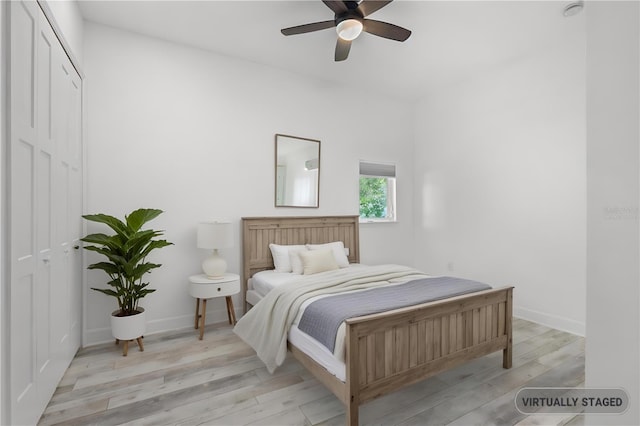 bedroom featuring ceiling fan, a closet, and light hardwood / wood-style flooring