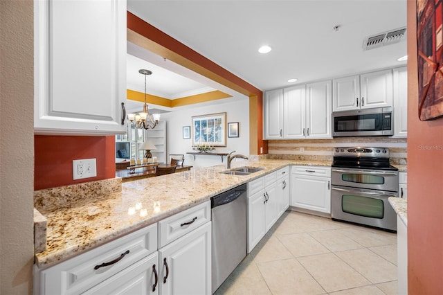 kitchen featuring appliances with stainless steel finishes, white cabinetry, an inviting chandelier, and sink