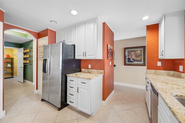 kitchen featuring light stone counters, light tile patterned floors, appliances with stainless steel finishes, and white cabinets