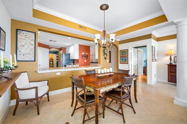 tiled dining space with ornamental molding, sink, a chandelier, and ornate columns