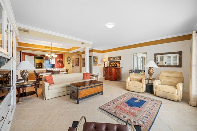 tiled living room with ornamental molding, an inviting chandelier, and decorative columns