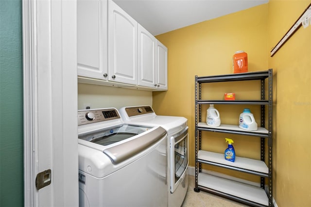 washroom featuring cabinets and washing machine and dryer