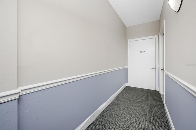 corridor with vaulted ceiling and carpet