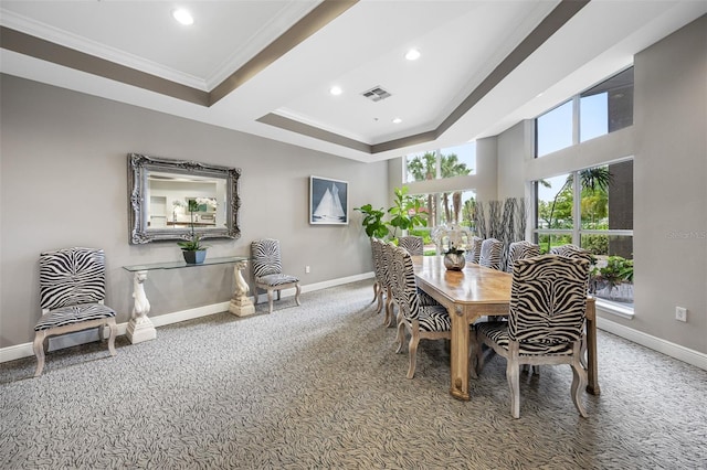 dining area featuring carpet flooring, a raised ceiling, and ornamental molding