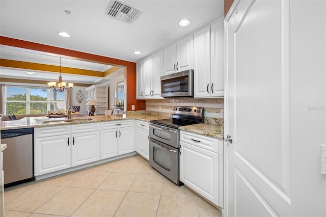 kitchen featuring an inviting chandelier, stainless steel appliances, white cabinetry, sink, and tasteful backsplash