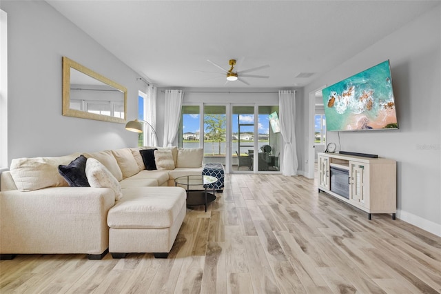 living room with light hardwood / wood-style flooring and ceiling fan