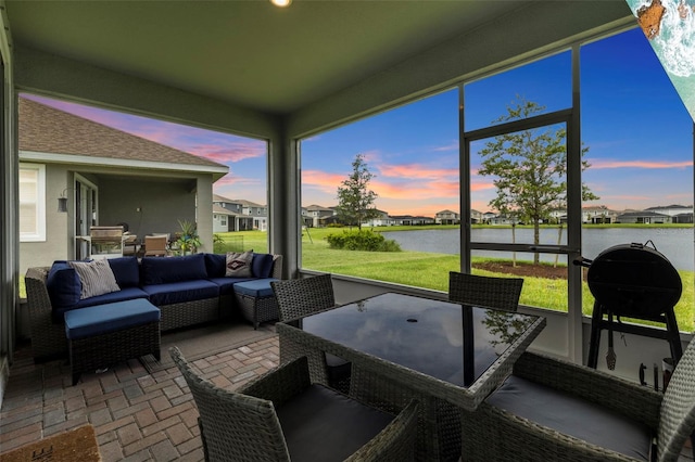 sunroom featuring a water view