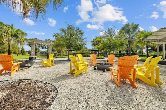 view of jungle gym with an outdoor fire pit and a pergola