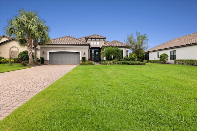 mediterranean / spanish house with a front lawn and a garage