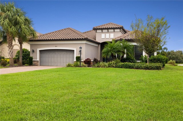 mediterranean / spanish-style house with a front lawn and a garage