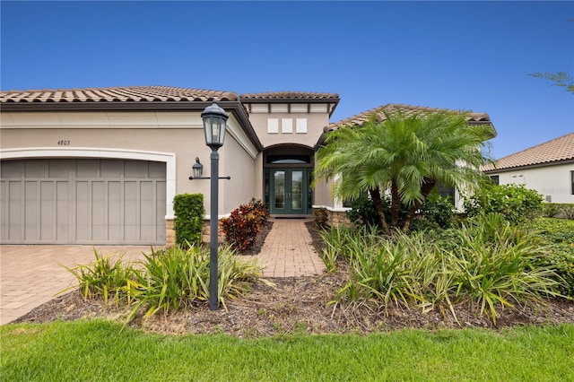 mediterranean / spanish home with a garage and french doors