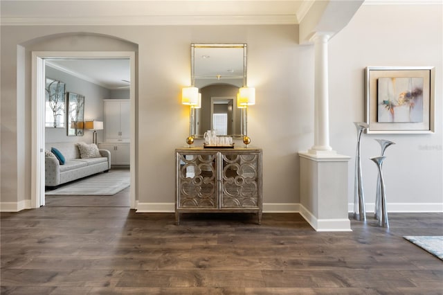 corridor with dark hardwood / wood-style floors, crown molding, and ornate columns