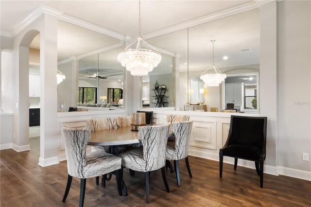 dining area with ceiling fan with notable chandelier, dark hardwood / wood-style flooring, and ornamental molding