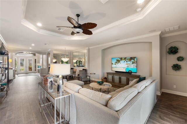 living room with ceiling fan, ornamental molding, a tray ceiling, and hardwood / wood-style flooring