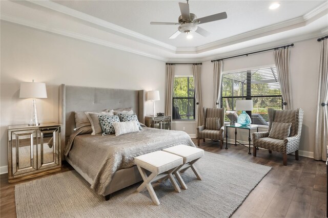 bedroom featuring a tray ceiling, crown molding, hardwood / wood-style floors, and ceiling fan