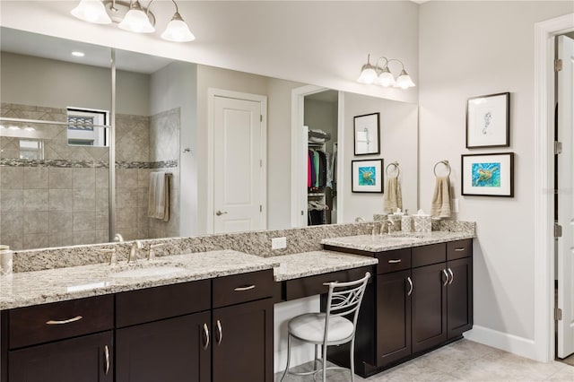 bathroom featuring tiled shower, vanity, and tile patterned floors