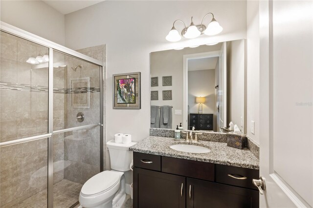 bathroom featuring walk in shower, toilet, and vanity