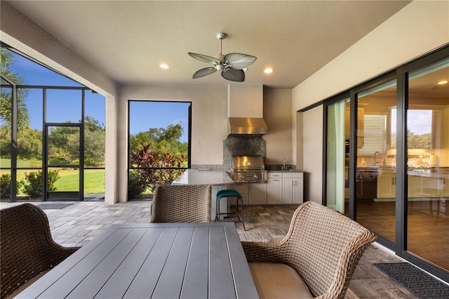 sunroom / solarium with ceiling fan and sink