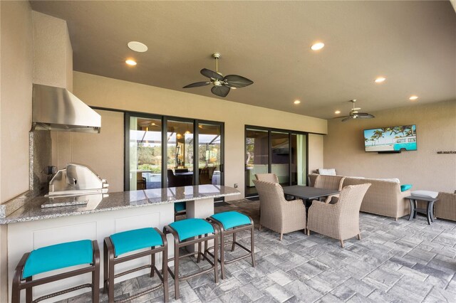 view of patio with exterior kitchen, area for grilling, and ceiling fan