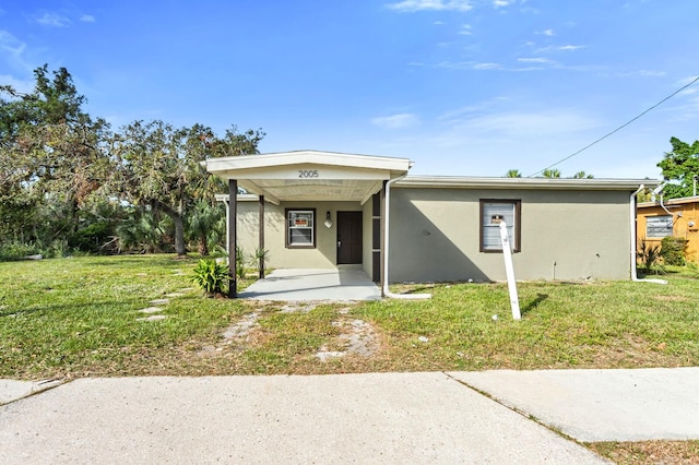 view of front of house featuring a carport and a front lawn