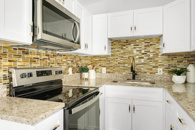 kitchen with white cabinets, decorative backsplash, stainless steel appliances, and sink