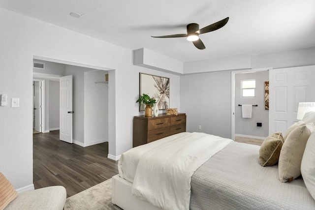 bedroom featuring dark wood-type flooring, connected bathroom, and ceiling fan