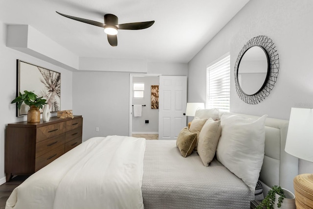 bedroom with hardwood / wood-style floors, ceiling fan, and ensuite bath