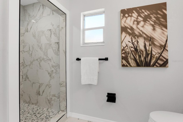 bathroom featuring toilet and a tile shower