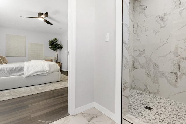 bathroom with hardwood / wood-style flooring, a tile shower, and ceiling fan