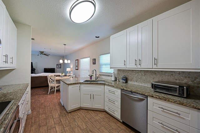 kitchen with white cabinetry, sink, kitchen peninsula, tasteful backsplash, and stainless steel dishwasher