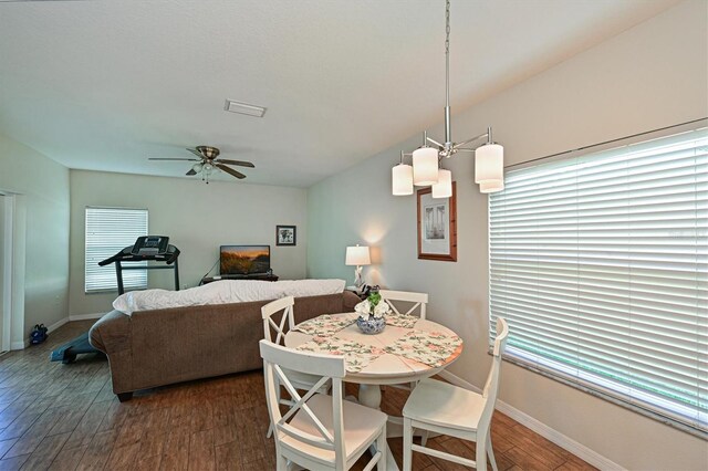 dining room featuring ceiling fan with notable chandelier and dark hardwood / wood-style flooring