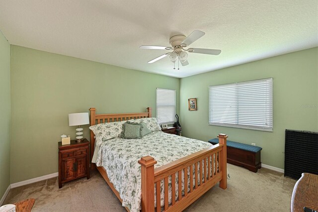 carpeted bedroom with a textured ceiling and ceiling fan